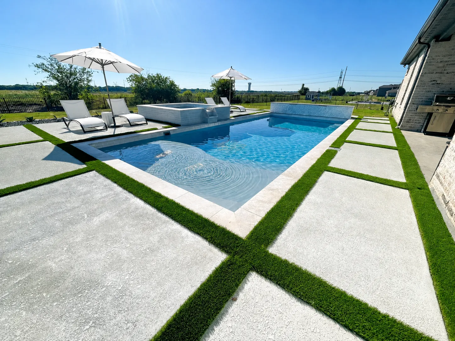 Modern pool with turf strips between concrete pavers