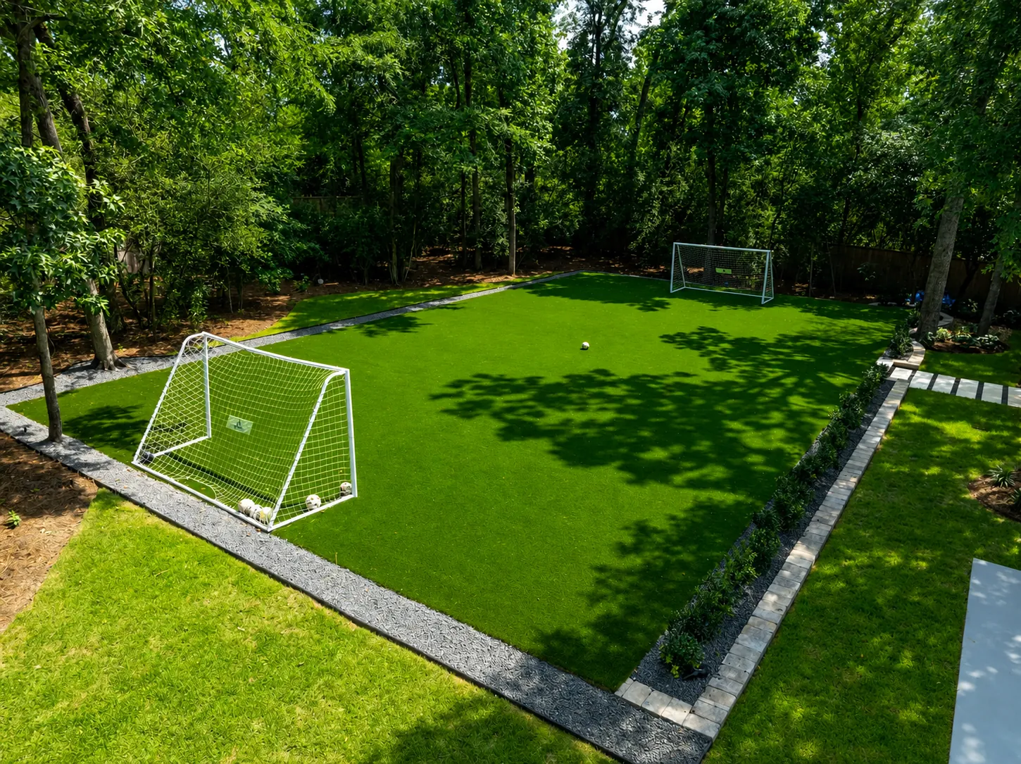 Backyard soccer field with goals surrounded by trees