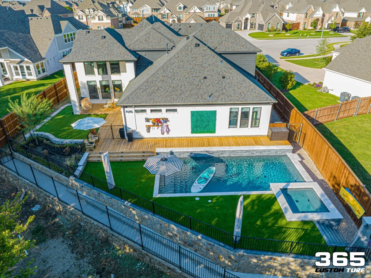 Aerial backyard with pool, deck, and full turf lawn