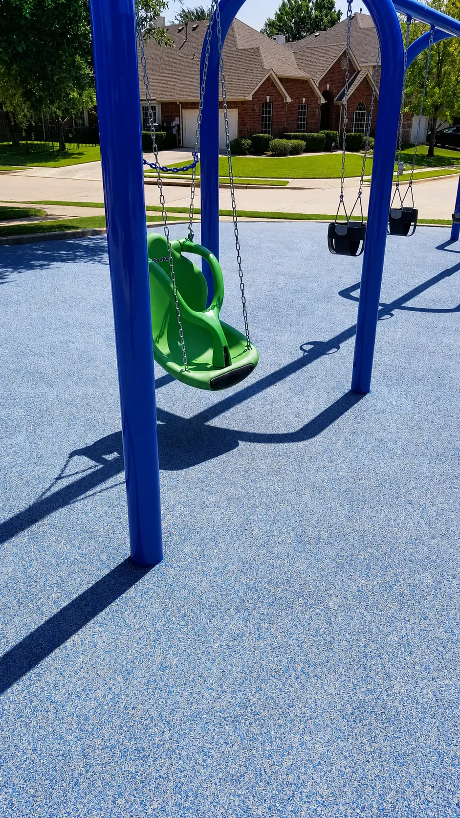 Playground swings with poured rubber surfacing