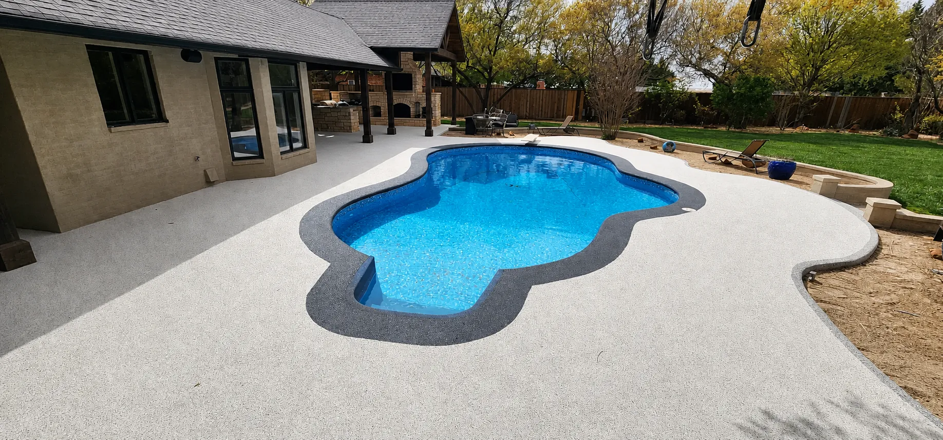 Pool deck with rubber surfacing and outdoor kitchen